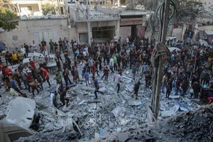 Người dân Palestine đứng giữa đống đổ nát của những tòa nhà bị phá hủy sau đòn không kích của Israel tại khu vực Al-Rimal, phía tây thành phố Gaza ngày 30/8/2025. (Ảnh: THX/TTXVN)