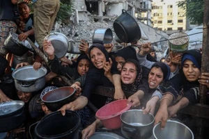 Người dân Palestine di dời khỏi chiến sự chờ nhận thực phẩm miễn phí từ một trung tâm phân phối thực phẩm ở thành phố Gaza, ngày 14/7/2025. (Ảnh: Xinhua)