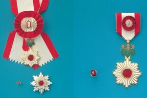 Huân chương Mặt trời mọc hạng nhất Đại Thập tự (trái) và Huân chương Mặt trời mọc có tia sáng vàng và nơ thắt hoa hồng (phải) của Nhật Bản. (Ảnh: Văn phòng Nội các Nhật Bản)