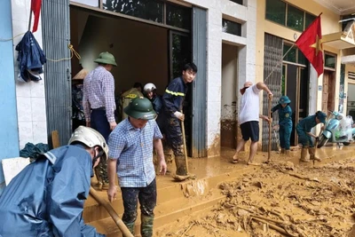 Lực lượng chức năng phường Cam Đường hỗ trợ nhân dân khắc phục hậu quả bão số 10.