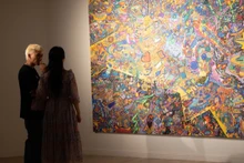 Họa sĩ Hoàng Anh Trung chia sẻ với phóng viên về quá trình sáng tạo. (Ảnh: Mơ Art Space)