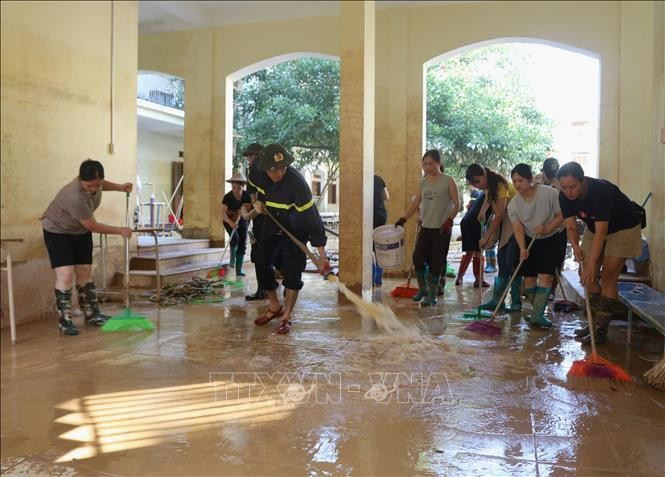 Giáo viên, lực lượng vũ trang tham gia khắc phục hậu quả cơn bão số 11 tại Trường trung học cơ sở Hợp Giang (phường Thục Phán). (Ảnh: Chu Hiệu/TTXVN)