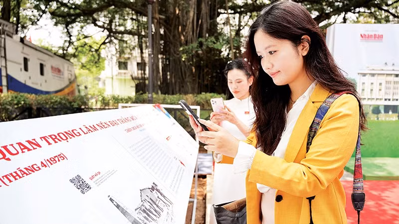 Các bạn trẻ quét mã QR xem thông tin các trận đánh tại triển lãm tương tác do Báo Nhân Dân tổ chức dịp kỷ niệm 50 năm Ngày Giải phóng miền nam, thống nhất đất nước. Ảnh | THẾ ĐẠI