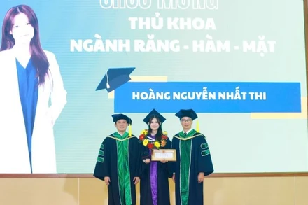 Đại diện lãnh đạo Trường đại học Khoa học sức khỏe khen thưởng tân bác sĩ Hoàng Nguyễn Nhất Thi.