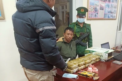 Đối tượng Thào A Pháng (người giữa) cùng tang vật khi bị Bộ đội Biên phòng tỉnh Điện Biên bắt giữ. 