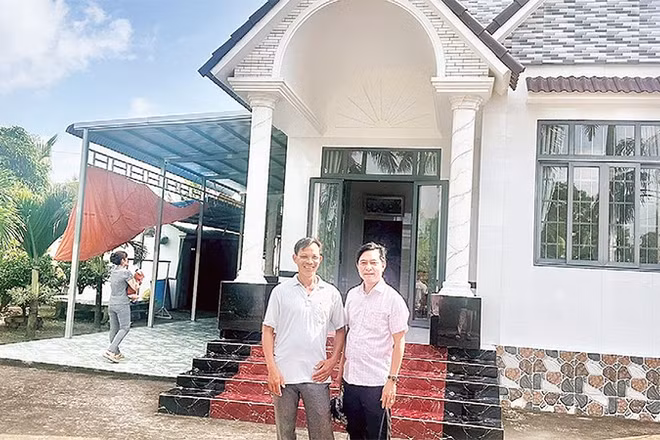 Nông dân Trần Quốc Thống (bên trái) trồng lúa ST 25 kết hợp nuôi tôm, mỗi năm thu lãi hơn một tỷ đồng, vừa xây nhà mới khang trang.