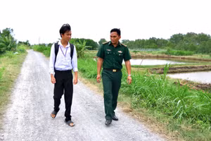 Con nuôi Phạm Văn Giàu chia sẻ ước mơ về con đường học tập cùng Thượng úy Thạch Minh Sỹ. (Ảnh: LÊ KHOA)