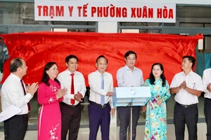 Đại biểu bấm nút đưa Trạm y tế Xuân Hòa vào hoạt động. 