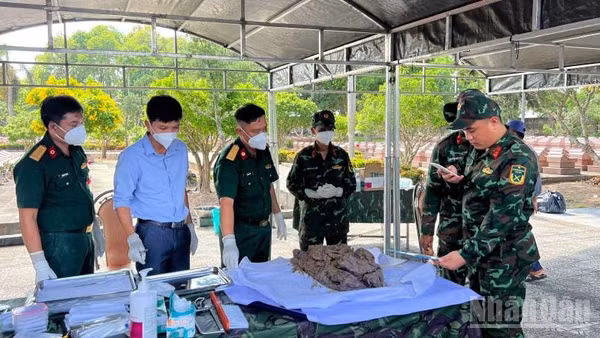 Lấy mẫu hài cốt liệt sĩ phục vụ giám định ADN tại Nghĩa trang Liệt sĩ Bến Tre. (Ảnh: HOÀNG TRUNG)