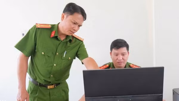 Thượng tá Cao Thành Nhân (trái) hướng dẫn cán bộ hoàn chỉnh hồ sơ quản lý địa bàn. (Ảnh: Đăng Khoa)