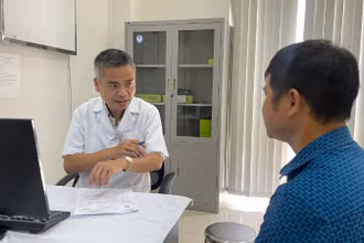 Tiến sĩ, bác sĩ Trần Huy Thọ, Phó Giám đốc Thường trực Bệnh viện Đặng Văn Ngữ, Viện Sốt rét-Ký sinh trùng-Côn trùng Trung ương tư vấn cho người bệnh đến khám bệnh lý ký sinh trùng. (Ảnh: THIÊN LAM)