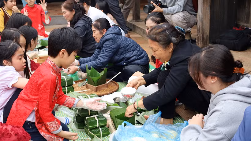 Các bạn nhỏ học cách gói bánh chưng.