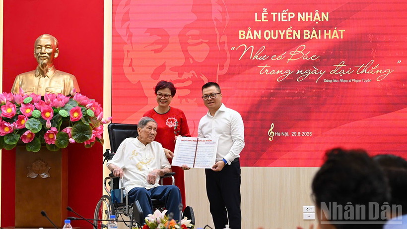 Tổng Biên tập Lê Quốc Minh nhận cuốn sổ ghi bài hát của nhạc sĩ Phạm Tuyên từ gia đình nhạc sĩ. (Ảnh: THÀNH ĐẠT)