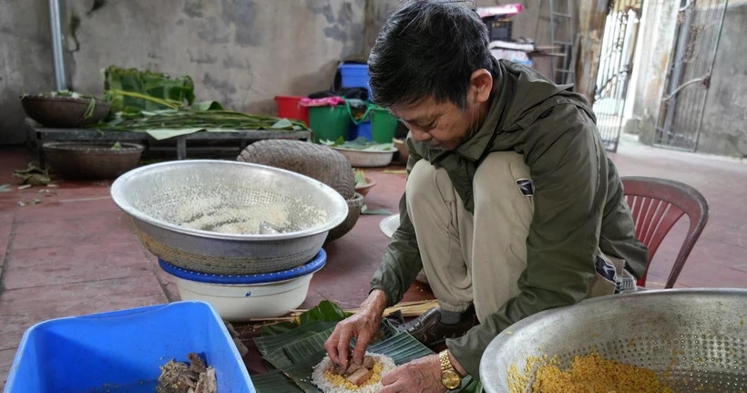 Ông Nguyễn Tất Lớ, làng Thủy Đường, gói bánh. (Ảnh: TTXVN)