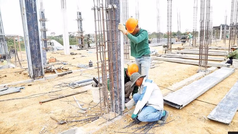 Các công nhân dựng trụ đổ bê-tông.