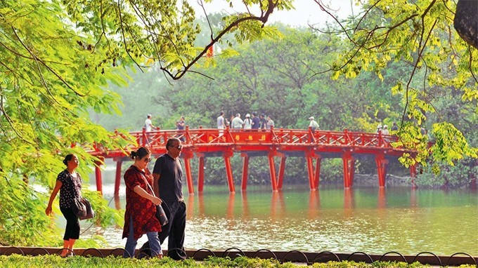 Khách du lịch nước ngoài đi dạo bên hồ Hoàn Kiếm. Ảnh: Duy Linh.