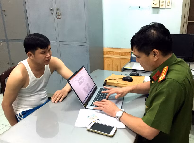 Điều tra viên lấy lời khai Ngô Quý Phương. (Ảnh: Công an cung cấp)