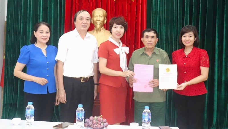 Lãnh đạo Văn phòng Hội đồng nhân dân và Ủy ban nhân dân quận Hai Bà Trưng, phường Vĩnh Tuy trao Giấy chứng nhận quyền sử dụng đất-quyền sở hữu nhà và giấy phép xây dựng cho gia đình ông Đặng Ngọc Tuy.