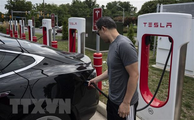Người dân sạc điện cho ô-tô tại một trạm sạc của Tesla ở Arlington, Virginia, Mỹ. (Ảnh: AFP/TTXVN)