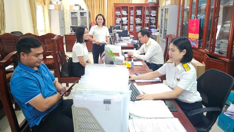 Cán bộ Chi cục Thuế khu vực Phúc Yên hướng dẫn người dân về thủ tục kê khai thuế. 