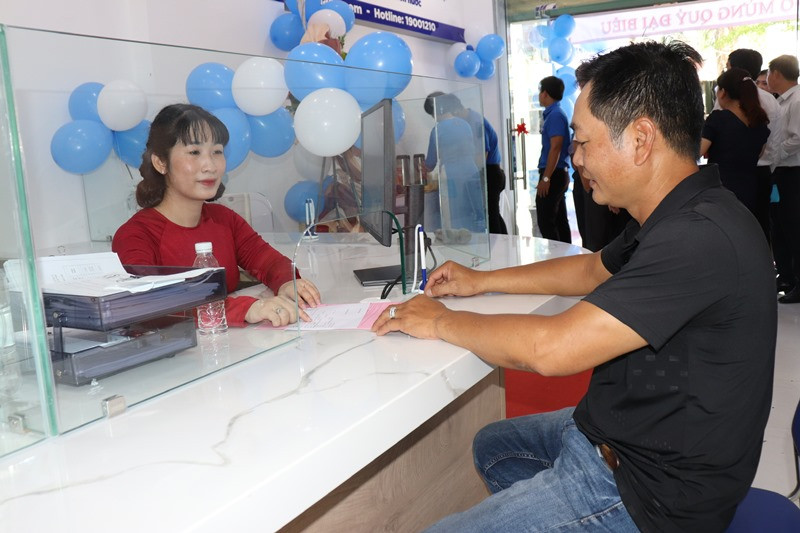 Nhân viên đơn vị cấp nước hướng dẫn thủ tục và thực hiện cấp định mức nước cho khách hàng.