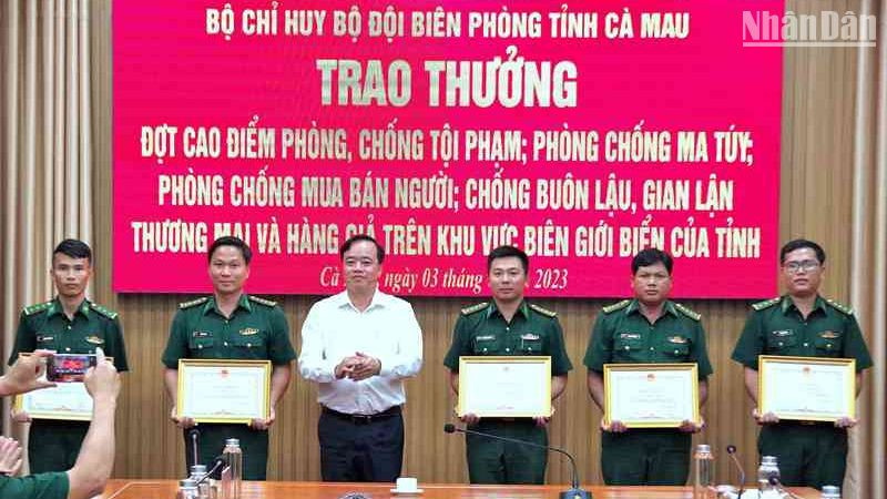 Chủ tịch Ủy ban nhân dân tỉnh Cà Mau Huỳnh Quốc Việt (áo trắng) tặng Bằng khen cho tập thể, cá nhân Biên phòng Cà Mau có thành tích tốt trong phá án về buôn lậu, ma túy.