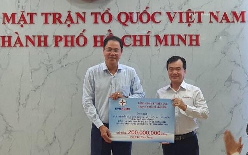 Ông Trần Vũ Quang, Trưởng Ban Kiểm tra - Thanh tra EVNHCMC (bên phải) trao số tiền 200 triệu đồng cho Quỹ “Vì biển đảo quê hương-Vì tuyến đầu Tổ quốc”.