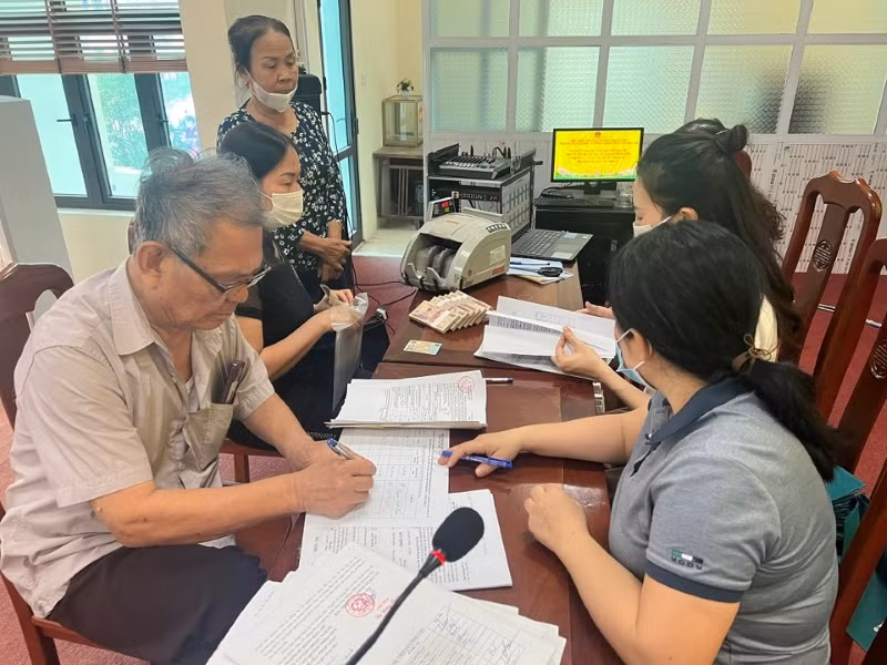 Người dân xã Đắc Sở, huyện Hoài Đức, Hà Nội, nhận tiền đền bù tại trụ sở UBND xã, sáng 12/5/2023. (Ảnh: Trần Thụ)