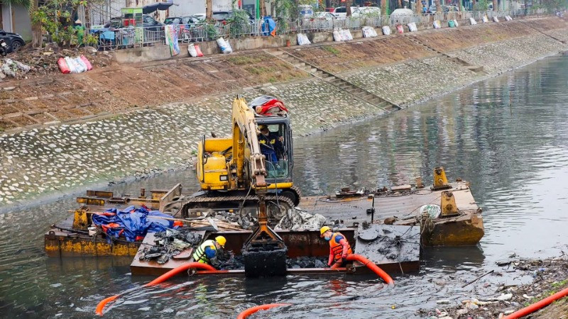 Công nhân Công ty Thoát nước Hà Nội tiến hành nạo vét bùn, cải tạo môi trường nước sông Tô Lịch. (Ảnh: TUẤN SƠN)