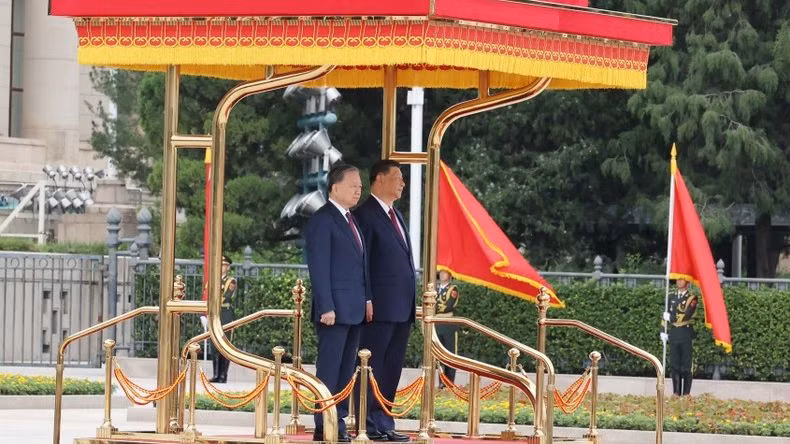 Tổng Bí thư, Chủ tịch nước Tô Lâm và Tổng Bí thư, Chủ tịch nước Trung Quốc Tập Cận Bình trên bục danh dự, nghe quân nhạc cử Quốc thiều hai nước. Ảnh: Trí Dũng – TTXVN