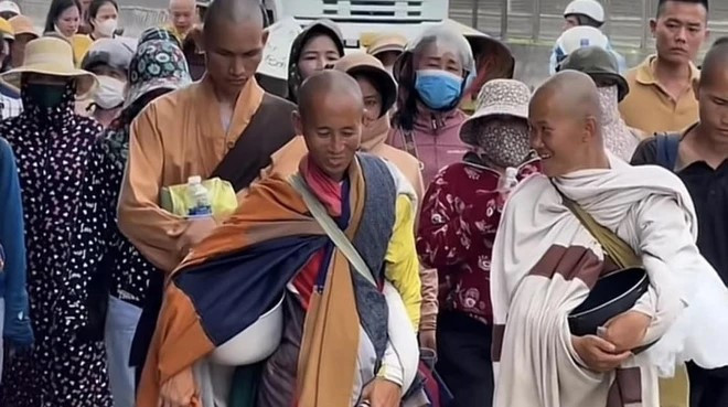 Ông Minh Tuệ (hàng đầu giữa) trong hành trình đi bộ từ Nam ra Bắc luôn thu hút sự hiếu kỳ của nhiều người. (ẢNH: VN/TTXVN)