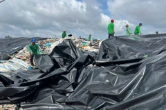 Các đơn vị liên quan tập trung khắc phục ô nhiễm môi trường tại bãi rác An Hiệp. (Ảnh: HOÀNG TRUNG)