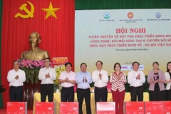 Đồng chí Huỳnh Thành Đạt và nhà báo Lê Nam Tư trao tặng 10 máy in Canon cho Ban Tuyên giáo và Dân vận các tỉnh, thành phố tham dự Hội nghị.