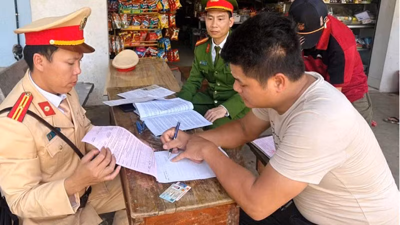 Công an lập biên bản vi phạm hành chính đối với người điều khiển ô-tô tải chở vật liệu, để đất rơi xuống đường.