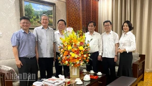 Đồng chí Nguyễn Trọng Nghĩa, Ủy viên Bộ Chính trị, Bí thư Trung ương Đảng, Trưởng Ban Tuyên giáo và Dân vận Trung ương tặng hoa chúc mừng nhà báo Đinh Thế Huynh. (Ảnh: VĂN TOÁN)