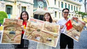 Các bạn trẻ hào hứng với phụ san đặc biệt của Báo Nhân Dân tuyên truyền kỷ niệm 50 năm Ngày Giải phóng miền nam, thống nhất đất nước.