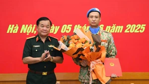 Thượng tướng Hoàng Xuân Chiến tặng hoa chúc mừng, động viên Thiếu tá Trần Viết Cường lên đường làm nhiệm vụ.