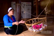 Người mẹ Mường dịu dàng ru con ngủ bên chiếc nôi tre.