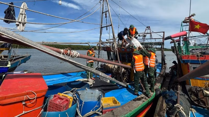 Cán bộ, chiến sĩ Đồn Biên phòng Diễn Thành hướng dẫn, giúp đỡ ngư dân neo đậu tàu thuyền phòng, chống bão số 5. (Ảnh: nhandan.vn) 