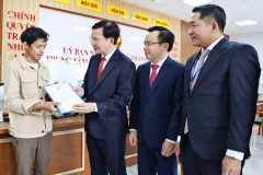 Chủ tịch UBND tỉnh Lâm Đồng Hồ Văn Mười tặng quà một người dân làm thủ tục đăng ký khai sinh cho con tại Trung tâm Phục vụ hành chính công xã Nhân Cơ