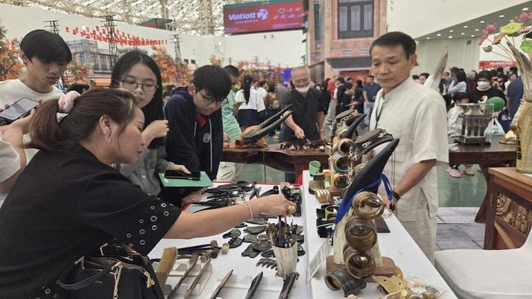 Khách hàng chọn mua đồ mỹ nghệ sừng tại hội chợ. z7163425473081-a635af445819a414e12071139d15f617.jpg