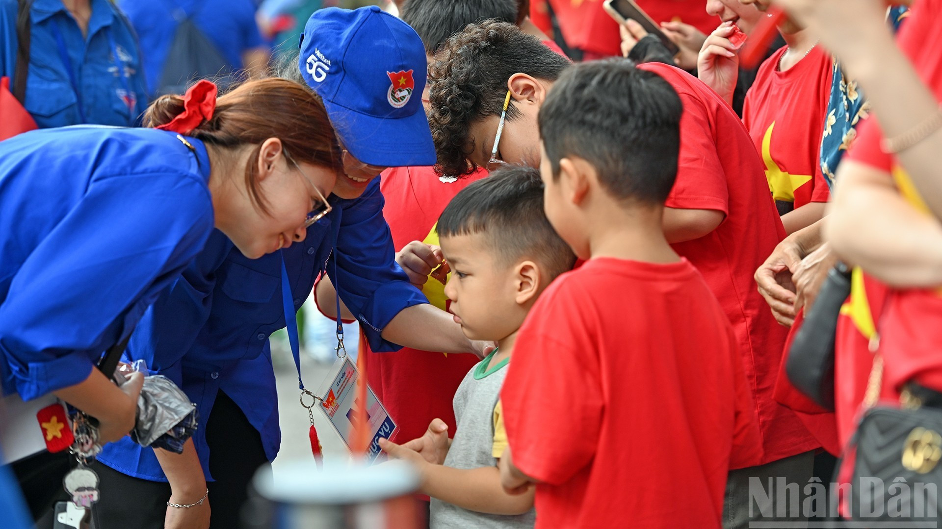 Các nữ tình nguyện viên hỗ trợ một em nhỏ trên địa bàn phường Cửa Nam (thành phố Hà Nội).