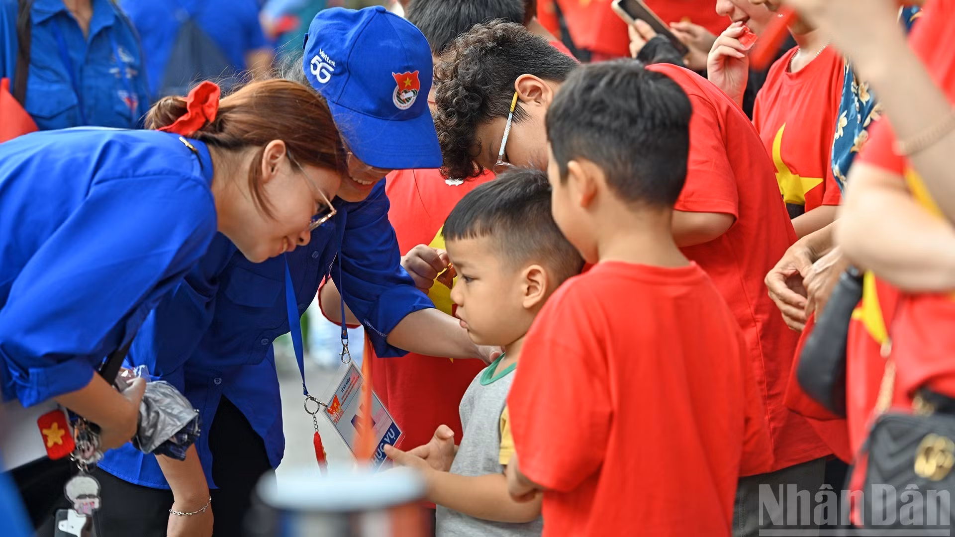 Các nữ tình nguyện viên hỗ trợ một em nhỏ trên địa bàn phường Cửa Nam (thành phố Hà Nội).
