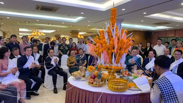 Các đại biểu dự lễ buộc chỉ cổ tay trong Tết cổ truyền Bunpimay của Lào. 