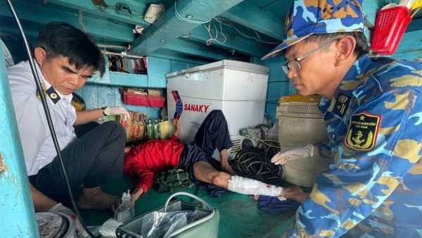 Quân y nhà giàn tiếp cận và vệ sinh, băng bó chân gãy cho nạn nhân.