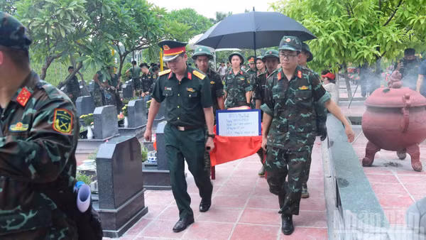Hài cốt liệt sĩ chưa xác định danh tính tại Nghĩa trang Mai Dịch (phường Phú Diễn) được cán bộ, chiến sĩ vận chuyển đến khu lấy mẫu. (Ảnh: HỮU THU)