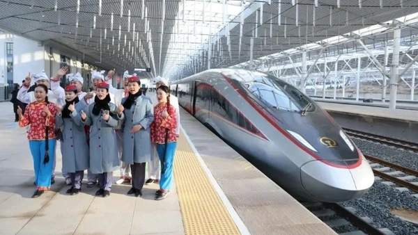 Nhân viên đường sắt và diễn viên chụp ảnh lưu niệm tại ga Diên An ngày 26/12. (Ảnh: China Daily)