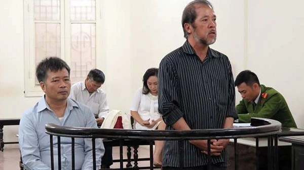 Hai bị cáo Nguyễn Đình Bang và Nguyễn Huy Khang tại một phiên sơ thẩm. (Ảnh: LÊ NHUNG)