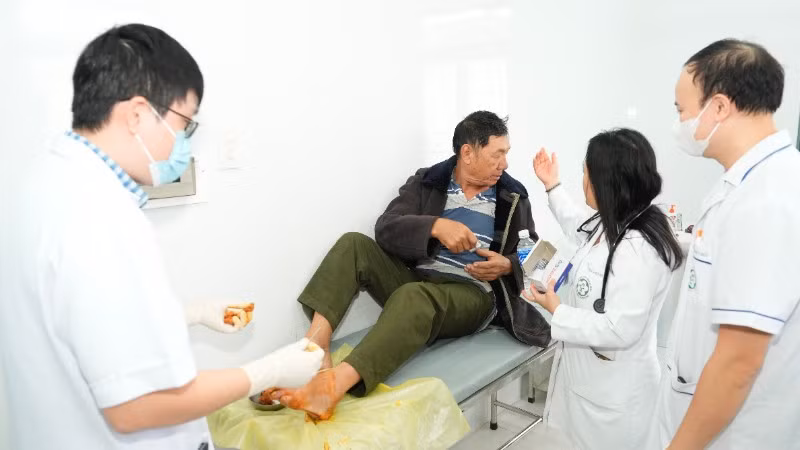 Các bác sĩ trong đoàn công tác trực tiếp xử trí một ca cấp cứu chấn thương bàn chân cho người.