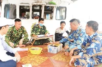 Lực lượng chức năng kiểm tra, xử lý tàu vi phạm tại bến cá.